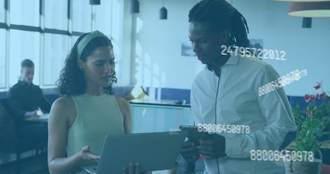 Diverse colleagues collaborating on digital data in modern office