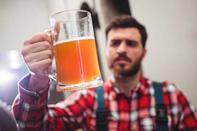 Manufacturer holding beer in jug at brewery