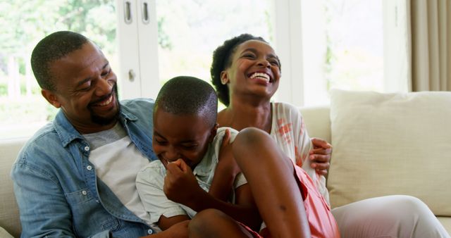 Family Laughing Together on Cozy Living Room Sofa - Download Free Stock Images Pikwizard.com