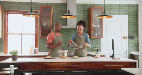 Couple Bonding While Cooking in Contemporary Kitchen