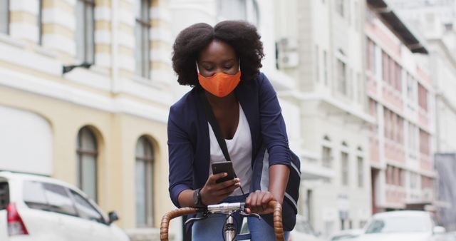 Woman Wearing Face Mask Riding Bicycle While Using Smartphone on Urban Street - Download Free Stock Images Pikwizard.com