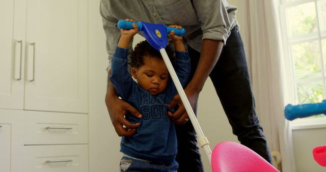 Father Helping Toddler Ride Tricycle Indoors by Window - Download Free Stock Images Pikwizard.com