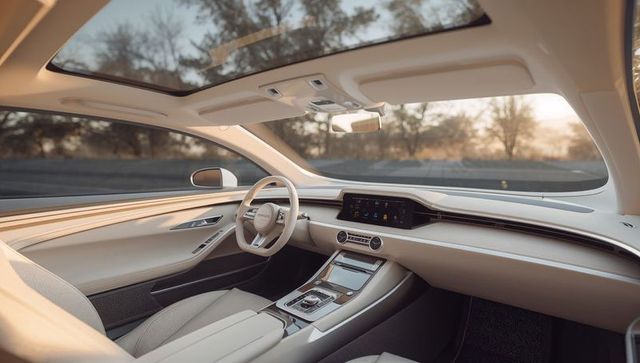 Luxury beige car interior with panoramic glass roof, digital infotainment and premium leather cabin