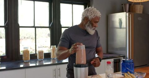 Mature african american man blending smoothie for healthy living lifestyle