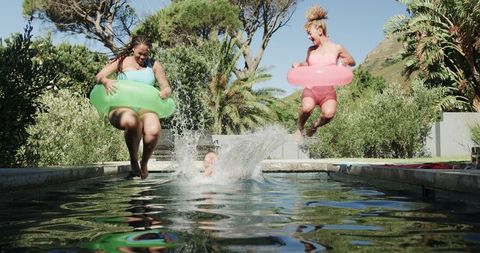 Friends Frolic in Pool on Sunny Day Surrounded by Nature - Download Free Stock Images Pikwizard.com