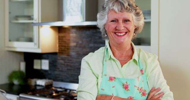 A joyful senior woman in an apron suggests a love for cooking in her kitchen. - Download Free Stock Photos Pikwizard.com