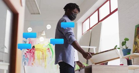 Artist with Canvas in Masked Creative Studio Marked by Vibrant Artwork