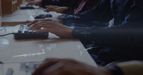 Hands typing on keyboard with data overlays displaying real-time analytics and teamwork