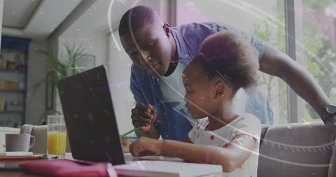 Father helping daughter with homework on laptop at home, remote learning, family support