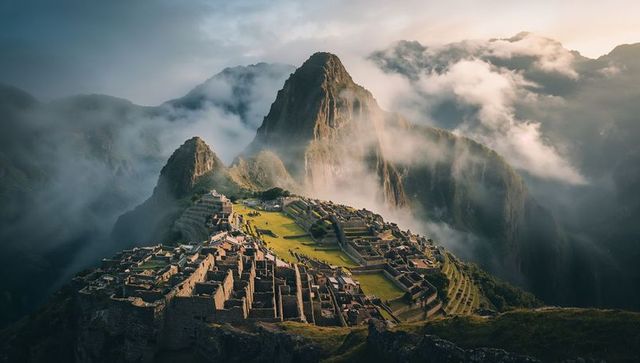 Sunlit ancient machu picchu ruins nestled in andean peaks with misty terraces at sunrise