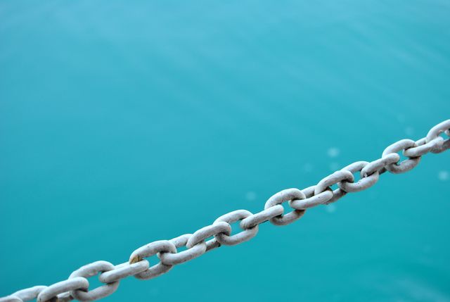 Rusty Chain Hanging Against Calm Blue Water Background - Download Free Stock Photos Pikwizard.com