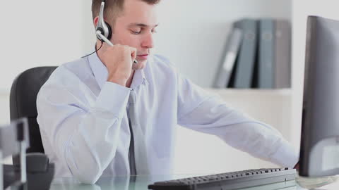 Businessman Using Headset Multitasking in Modern Office
