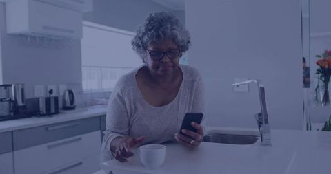 Senior Woman Engaged with Technology in Modern Kitchen