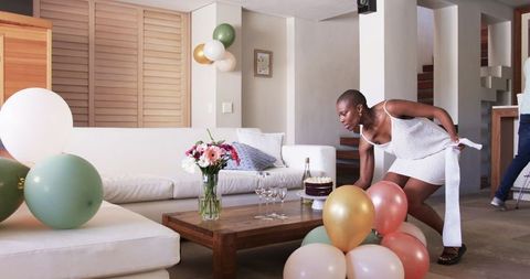 Excited Friends Preparing for a Birthday Celebration at Home