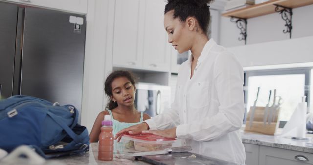 Mother Preparing Breakfast in Kitchen with Daughter Watching - Download Free Stock Images Pikwizard.com