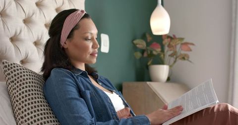 Woman Relaxing with Book in Bedroom Featuring Modern Decor