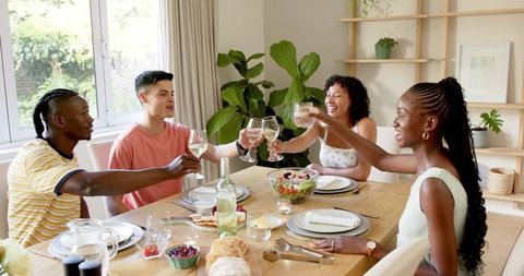 Diverse Friends Sharing Joyful Lunch at Home