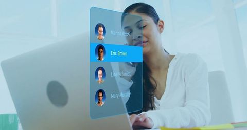 Remote professional using holographic contact interface while multitasking on laptop