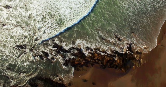 Aerial View of Wave Crashing on Rocky Shoreline at Beach - Download Free Stock Images Pikwizard.com