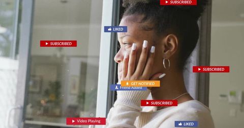 Woman looking out glass door with social media notification graphics, contemplative moment
