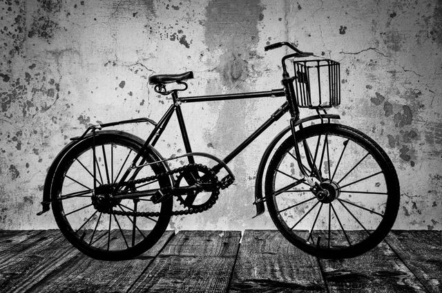 An vintage bicycle standing against a grungy, peeling wall. The image has a rustic and nostalgic feel, perfect for use in retro-themed designs, advertisements for vintage or classic bicycle shops, or home decor related to transport and cycling.