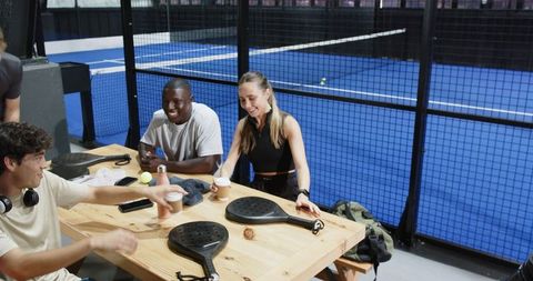 Diverse Friends Enjoying Coffee at Padel Court Table