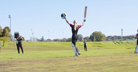 Woman Cricketer Celebrating Victory on Sunny Day Field