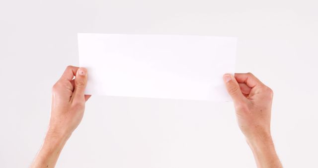 Hands Holding Blank White Paper Against White Background - Download Free Stock Images Pikwizard.com