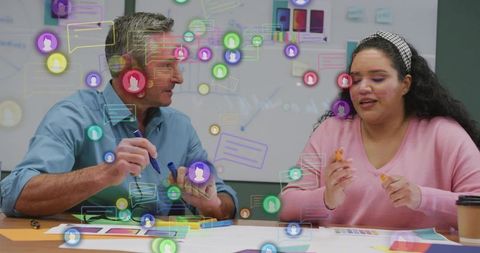 Collaborating over design mockups in boardroom team planning with colorful chat icons