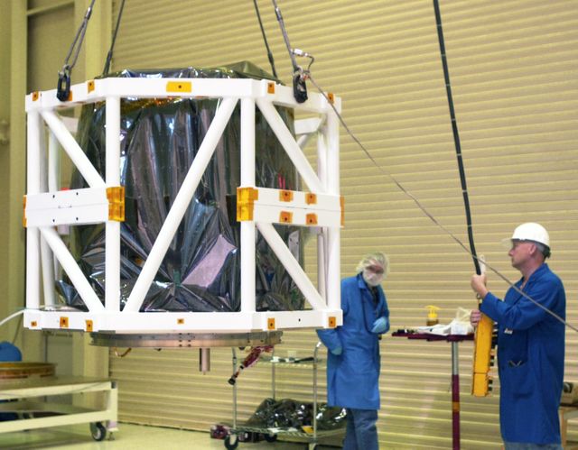 In Building 1555 on North Vandenberg Air Force Base in California, technicians lift the AIM spacecraft via the spacecraft handling fixture attached to it. AIM, which stands for Aeronomy of Ice in the Mesosphere, is being prepared for integrated testing and a flight simulation. The AIM spacecraft will fly three instruments designed to study polar mesospheric clouds located at the edge of space, 50 miles above the Earth's surface in the coldest part of the planet's atmosphere. The mission's primary goal is to explain why these clouds form and what has caused them to become brighter and more numerous and appear at lower latitudes in recent years. AIM's results will provide the basis for the study of long-term variability in the mesospheric climate and its relationship to global climate change. AIM is scheduled to be mated to its launch vehicle, Orbital Sciences' Pegasus XL, during the second week of April, after which final inspections will be conducted. Launch is scheduled for April 25.