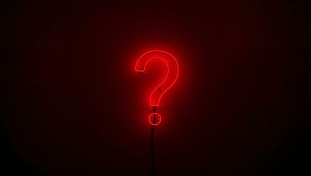 Glowing Red Neon Question Mark Sign on Dark Wall Minimal Conceptual Symbol with Tubing