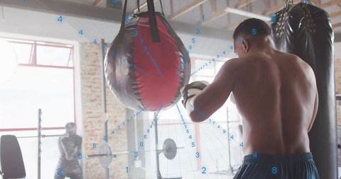 Shirtless Boxer Training Intensively with Focus on Speed Bag