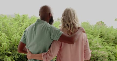Interracial mature couple embracing in scenic nature
