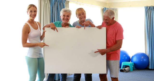 Happy Seniors and Instructor Holding Blank Signboard in Gym - Download Free Stock Images Pikwizard.com