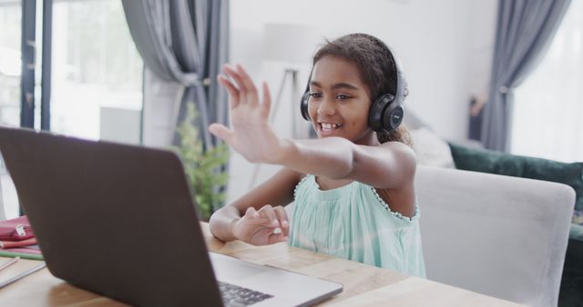 Smiling Young Girl Wearing Headphones Happy and Waving During Video Call at Home - Download Free Stock Images Pikwizard.com