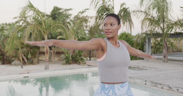 Woman Practicing Yoga Near Swimming Pool Surrounded by Palm Trees - Download Free Stock Images Pikwizard.com