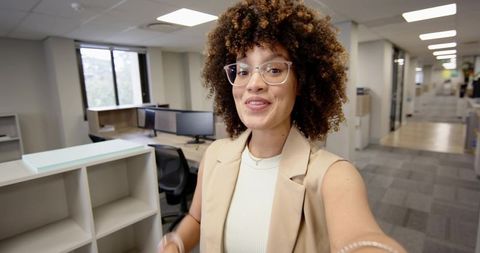 Confident businesswoman filming in modern open-plan office