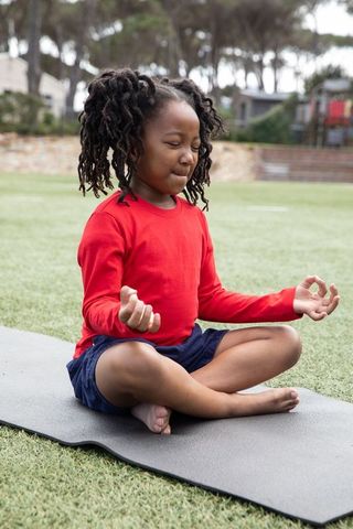 Child Meditating Outdoors in Park Promoting Mindfulness and Peace