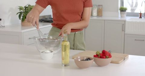Home cook preparing ingredients in modern white kitchen