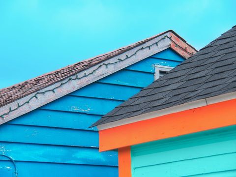 Vibrant layered roofs and colorful siding of coastal huts showcasing turquoise and orange accents