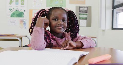 Young Student Highlighting Workbook in Eco-Friendly Classroom