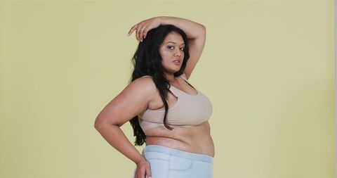 Confident Plus Size Woman Posing Against Yellow Background