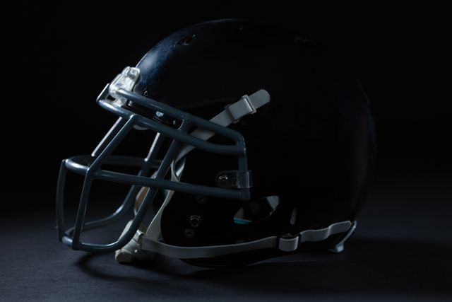 Close-up of American football head gear on a black background