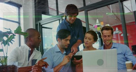Diverse team collaborating over tablet and laptop in bright modern office, business casual