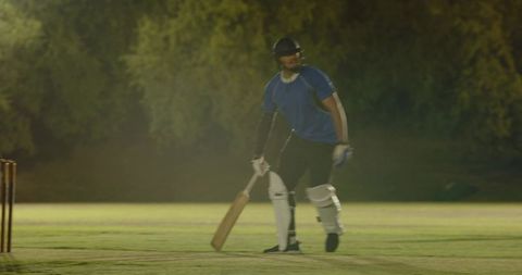 Night cricket batsman driving run under floodlights during intense training session