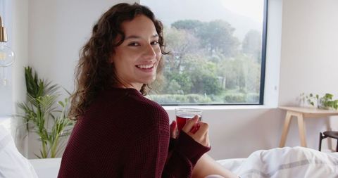 Woman Enjoying Cozy Morning with Beverage by Window