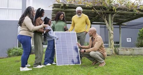 Multigenerational Family Exploring Solar Panel in Backyard, Learning Renewable Energy Together
