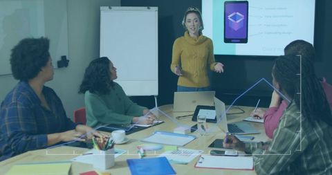 Confident Professional Presenting Mobile App to Team in Modern Meeting Room