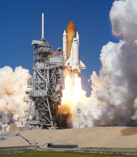 This image captures the historic lift-off of the Space Shuttle Discovery from launch pad 39B at NASA's Kennedy Space Center on October 29, 1998. The dramatic plume of exhaust shows the power necessary to escape Earth's gravity. This launch marks the start of a nine-day mission in Earth orbit. This image is suitable for use in articles, presentations, or educational materials about space exploration, NASA missions, or the history of human spaceflight. It can also be used in aerospace-related promotional materials.