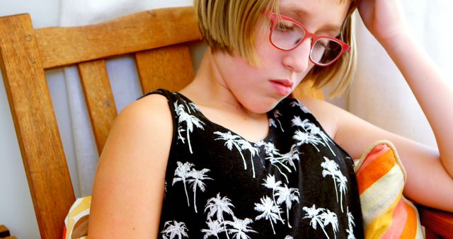 Young Girl with Glasses Reading Intently on Wooden Bench - Download Free Stock Images Pikwizard.com